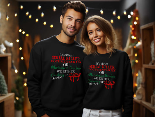 Couple wearing black sweatshirts featuring the phrase &quot;It&#39;s Either Serial Killer Documentaries or Christmas Movies.  We either Sleighing or Slayin&quot; in festive red and green lettering.