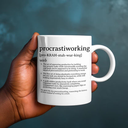 White ceramic mug reading &#39;procrastiworking&#39; definition, held against a moody blue gradient background.