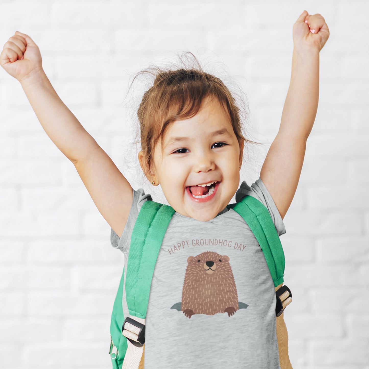 Happy girl wearing a lt heather grey tee with Happy Groundhog day with a cute cubby groundhog printed on the t-shirt