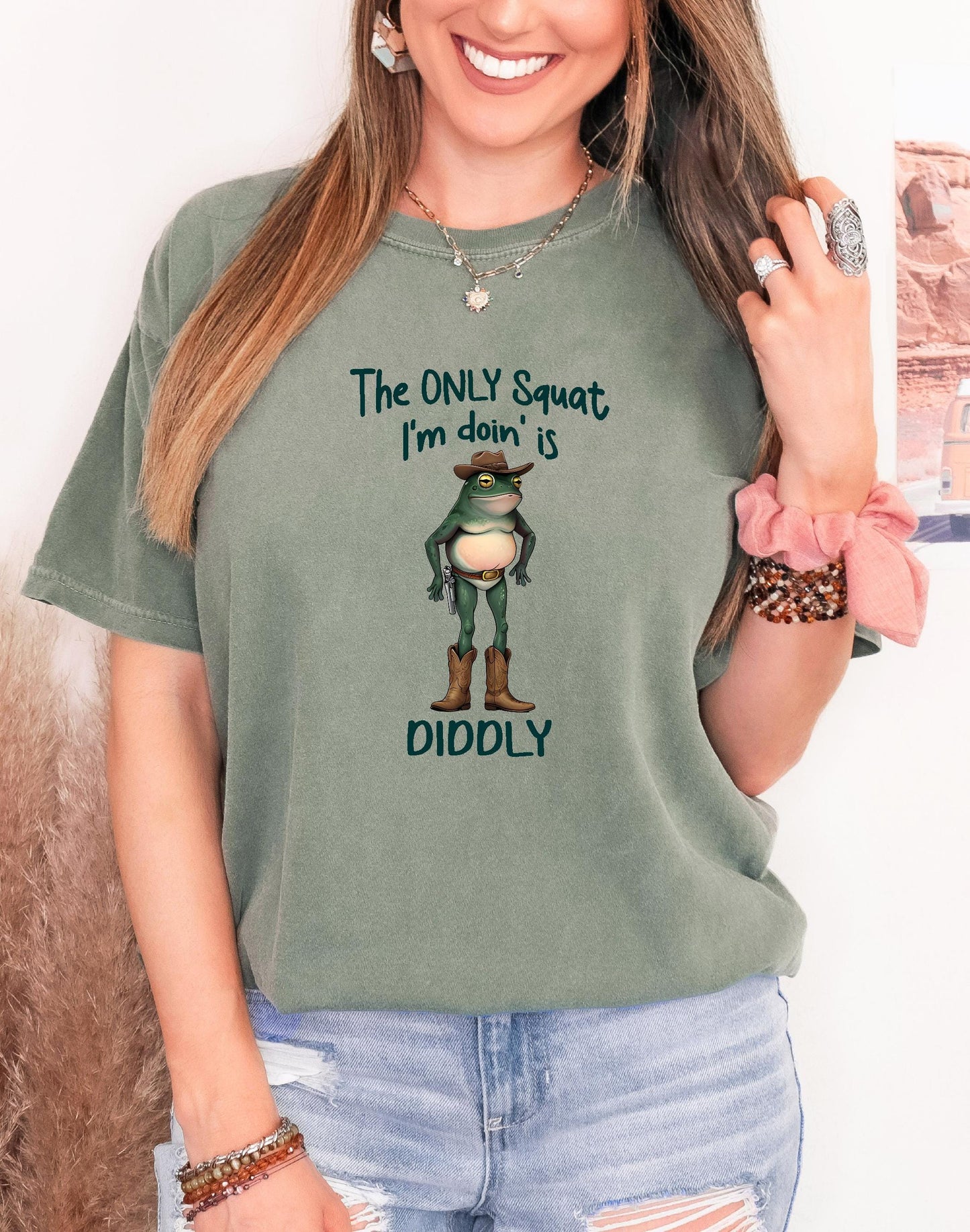 Funny cowboy frog graphic tee with “The only squat I&#39;m doin’ is diddly” on a moss Comfort Colors shirt, perfect for weirdcore cottagecore fans.