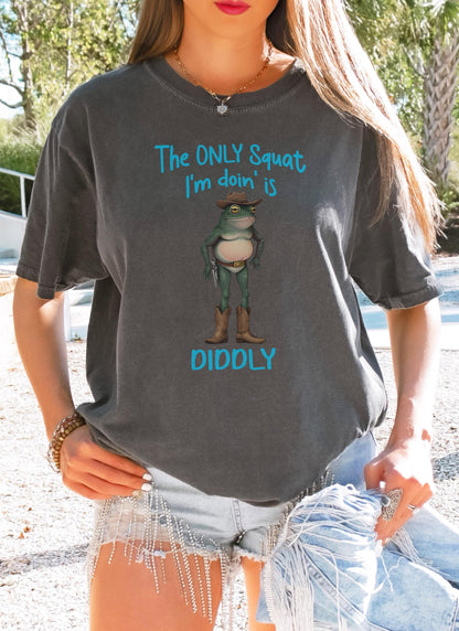 Funny cowboy frog graphic tee with “The only squat I&#39;m doin’ is diddly” on a pepper Comfort Colors shirt, perfect for weirdcore cottagecore fans.