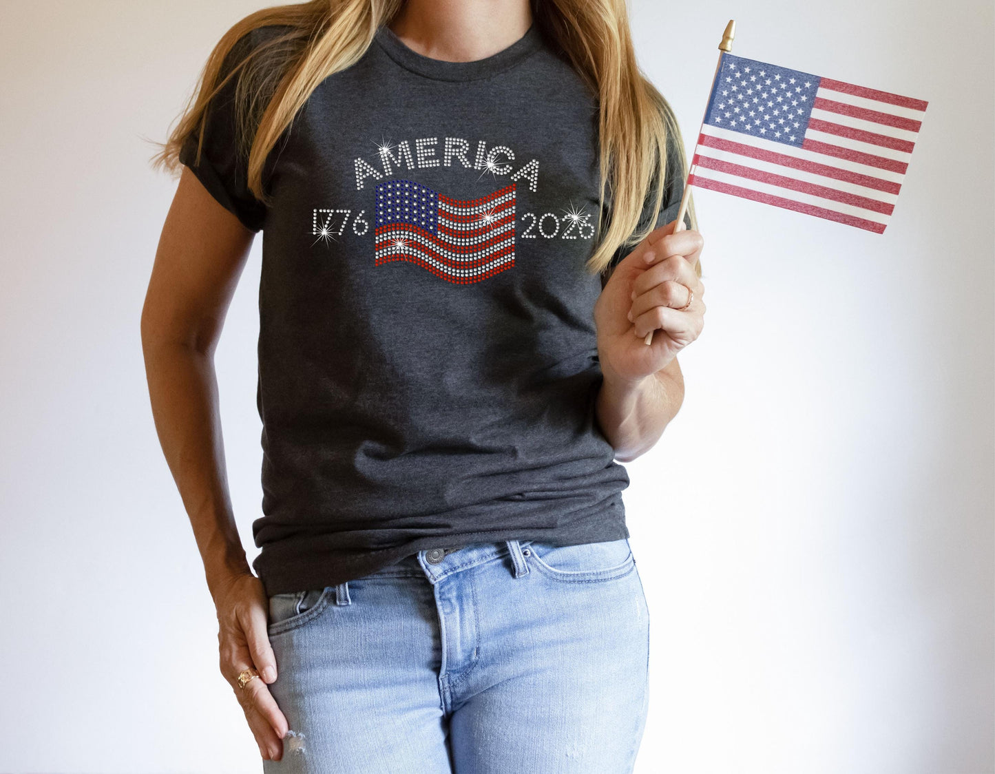 Close-up of dark heather grey t-shirt with rhinestone flag and “America 1776–2026” design.