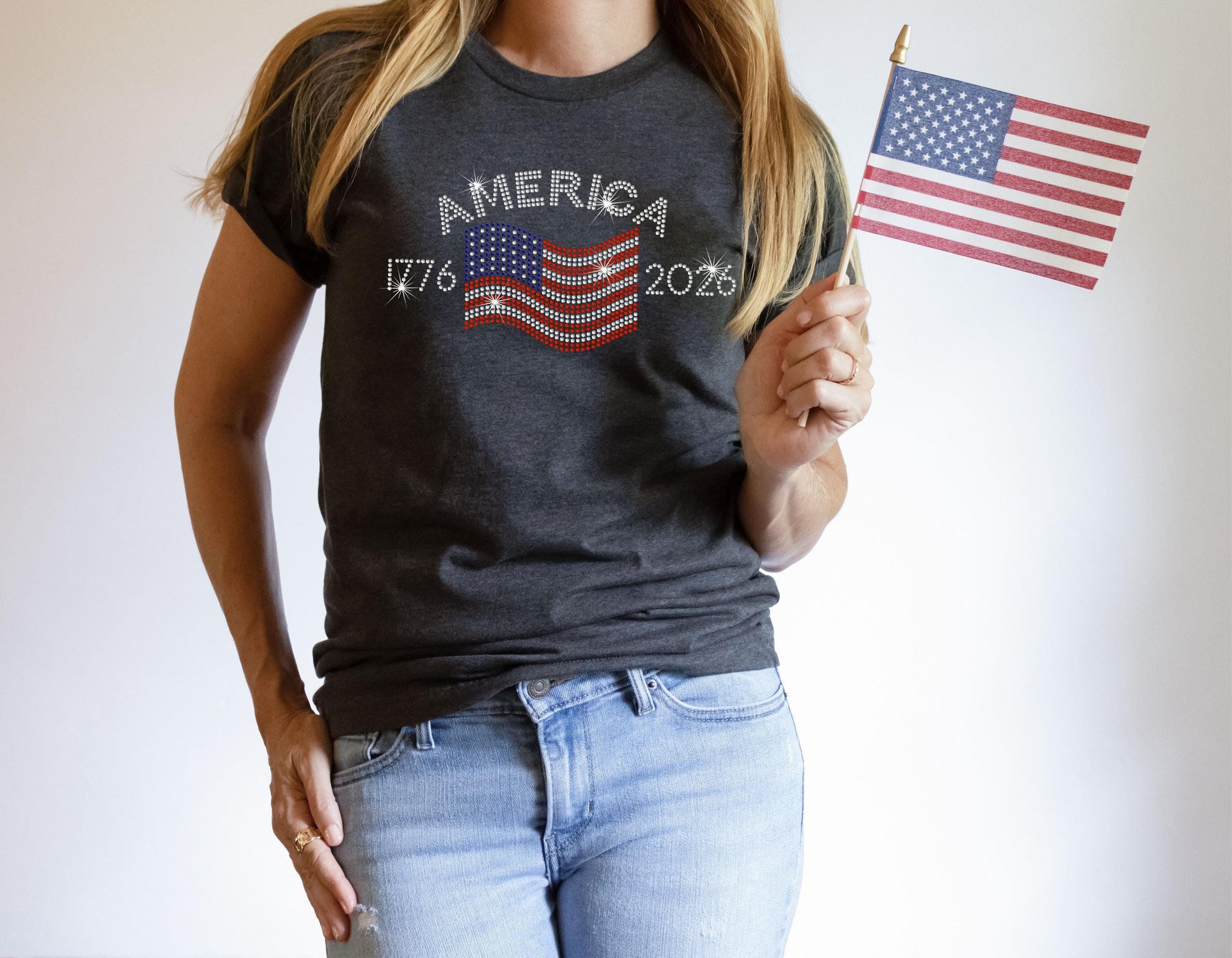 Close-up of dark heather grey t-shirt with rhinestone flag and “America 1776–2026” design.
