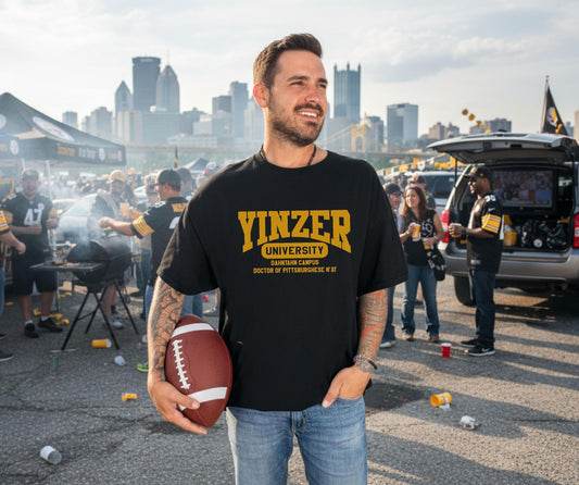 Black t-shirt with gold Yinzer University text, Pittsburgh skyline background, funny local slang gift.