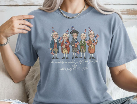 Woman wearing a washed denim blue t-shirt with cartoon Founding Fathers in party hats holding American flags.